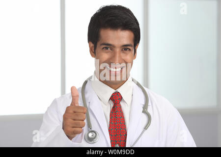Maschio indiano medico mostrando pollice in alto segno Foto Stock