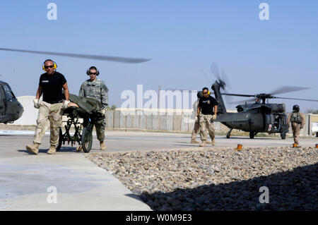 Stati Uniti Air Force e l'esercito medics scaricare evacuazione medica (MEDEVAC) passeggeri off a UH-60 Black Hawk elicottero, presso la Air Force Theatre ospedale di Balad Air Base, Iraq Mercoledì, 2 agosto 2006. L'ospedale fornisce il livello 1 il trauma e specializzata di cure mediche in tutto l'Iraq. (UPI foto/Andrew Oquendo/Air Force) Foto Stock