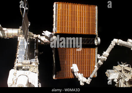 Ancorata alla Stazione Spaziale Internazionale il Canadarm2 piedi moderazione, astronauta Robert L. Curbeam Jr. e Agenzia spaziale europea (ESA) astronauta Christer Fuglesang (centro), entrambi STS-116 specialisti di missione, il lavoro con il sovraccarico porta solar array ala sulla stazione della P6 truss durante la missione della quarta sessione della attività extravehicular (EVA) il 18 dicembre 2006. L'inizio utilizzato appositamente preparato, nastro-attrezzi isolati, per guidare l'ala array ordinatamente all'interno della sua scatola di copertura durante le 6 ore, 38-minute spacewalk. (UPI foto/NASA) Foto Stock