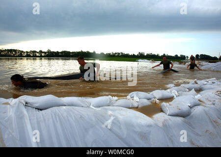 Marines e marinai del Battaglione Team di atterraggio 2/6, 26 Marine Expeditionary Unit, spostare un tubo attraverso l'acqua dal fiume Bianco in Elnore, Indiana il 9 giugno 2008. Le autorità locali in Elnora ha richiesto la ventiseiesima meu a fornire assistenza per rafforzare gli argini di esondazione del fiume Bianco. (UPI foto/Lancia Cpl. Patrick M. Johnson-Campbell/USMC) Foto Stock