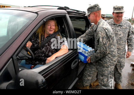 Un ritorno Gulfport, Mississippi evacuee orologi come membro del Mississippi Esercito Nazionale luoghi di riparo acqua nella sua auto in corrispondenza di un punto di distribuzione appena fuori di Gulfport il 2 settembre 2008. Cittadini iniziato il rientro di ieri dopo l'uragano Gustav impone una evacuazione dell'area. (UPI foto/Michael J. Carden/DOD) Foto Stock