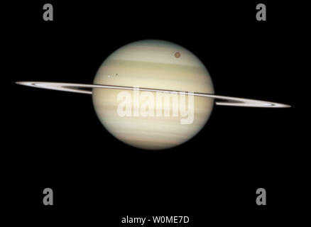 Il 24 febbraio 2009, la NASA/ESA Telescopio Spaziale Hubble catturato una sequenza fotografica di quattro lune di Saturno passando davanti a loro pianeta madre. Le lune, da sinistra a destra, sono il bianco icy moons Enceladus e Dione, la grande luna arancione Titan, e gelido Mimas. A causa dell'angolazione del sole, ciascuno di essi è preceduto dalla propria ombra. (UPI foto/NASA, l'ESA e il telescopio Hubble Heritage Team) Foto Stock