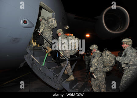 Un gruppo di soldati da Charlie Company, 2° Battaglione, Ventiduesimo reggimento di fanteria della decima divisione di montagna il primo combattimento vigili del Team, a bordo di una C-17 piano di trasporto di discostarsi Fort Drum, New York, per l'Afghanistan, il 9 gennaio. 'Triple Deuce" è il primo di sei battaglioni dal 1° BCT che stanno distribuendo con la truppa surge a sostegno dell'Operazione Enduring Freedom. UPI/John Queen/STATI UNITI Esercito Foto Stock