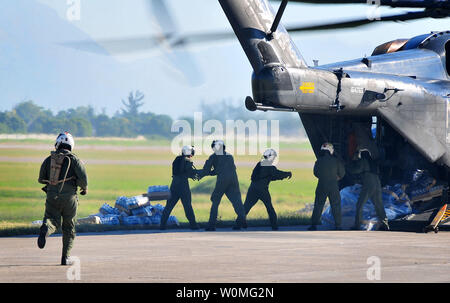 Stati Uniti I soldati dell esercito scaricare il cibo e le forniture su 15 Gennaio 2010 da un U.S. Navy MH-53E mare Dragon elicottero dalla portaerei USS Carl Vinson (CVN 70) all aeroporto di Port-au-Prince, Haiti. Il militare degli Stati Uniti sta conducendo missioni umanitarie e di soccorso in caso di catastrofe operazioni dopo un terremoto di magnitudine 7.0 hanno provocato gravi danni vicino a Port-au-Prince su gennaio 12. UPI/Candice B. Villarreal/STATI UNITI Navy. Foto Stock