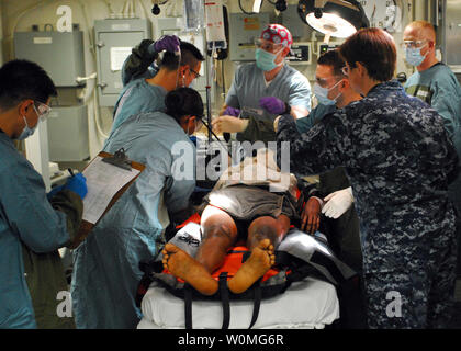 Il personale medico a bordo della multi-purpose Amphibious Assault nave USS Bataan (LHD 5) fornire cure mediche ad una donna trasferito in aereo il 19 gennaio 2010 di Bataan da un piccolo villaggio nelle vicinanze di Port-au-Prince, Haiti. Bataan è il supporto di funzionamento risposta unitaria, un' operazione congiunta la fornitura di assistenza umanitaria a seguito di un terremoto di magnitudine 7.0 che ha devastato la nazione insulare Gen 12, 2010. UPI/Ryan Steinhour/STATI UNITI Navy Foto Stock