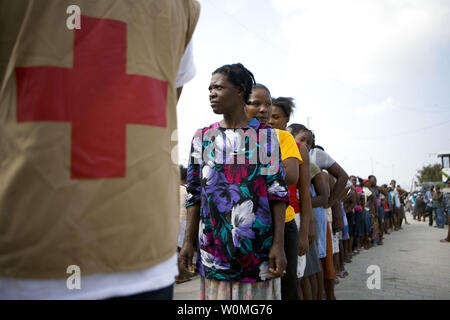 Samilia Giuseppe (L) attende in una linea di centinaia di ricevere forniture distribuito dalla Croce Rossa Americana in Croix Desprez, Port-au-Prince, Haiti il 20 gennaio 2010. La capitale haitiana e le aree circostanti sono state devastate dopo un terremoto di magnitudine 7.0 del 12 gennaio. UPI/Talia Frenkel/la Croce Rossa americana Foto Stock