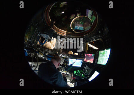 In questo 'fish-eye' vista lente, NASA astronaut Garrett Reisman, STS-132 lo specialista di missione, è circondato da Windows e i computer della stazione spaziale internazionale della Cupola il 18 maggio 2010. UPI/NASA. Foto Stock