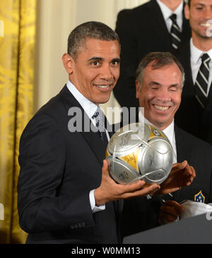 Stati Uniti Il presidente Barack Obama tiene un pallone da calcio con la galassia della LA head coach Bruce Arena durante una Sala Est cerimonia in onore di giocatori e allenatori dalla Major League Soccer (MLS) champions la galassia e il Los Angeles National Hockey League (NHL) champions Los Angeles Kings alla Casa Bianca di Washington, DC, Marzo 26, 2013. UPI/Pat Benic Foto Stock