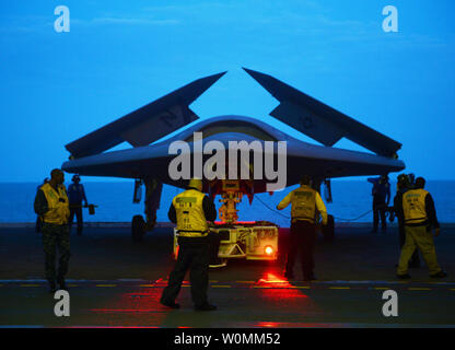 Un X-47B Unmanned Combat Air System (UCAS) dimostrante viene rimorchiato nella baia di hangar della portaerei USS George H.W. Bussola (CVN 77) Lunedì, 13 maggio 2013. USS George H.W. Bush è programmato per essere la prima portaerei a catapultare il lancio di un velivolo senza equipaggio dal suo ponte di volo. UPI/ Timothy Walter/STATI UNITI Navy Foto Stock