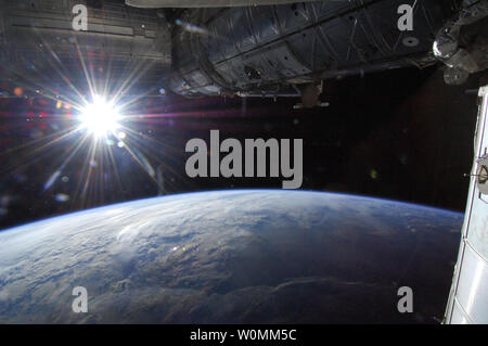 Il sole è catturato in un 'Starburst' mode su terra orizzonte da uno della spedizione 36 membri di equipaggio a bordo della Stazione spaziale internazionale, come avamposto orbitale è stata al di sopra di un punto nel sud-ovest del Minnesota il Maggio 21, 2013...UPI/NASA Foto Stock