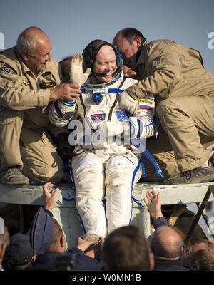 Expedition 40 Tecnico di volo Oleg Artemyev di l'agenzia Spaziale Federale Russa Roscosmos () onde come egli è aiutato fuori della capsula Soyuz a pochi minuti dopo che lui e tecnico di volo Alexander Skvortsov di Roscosmos e Expedition 40 comandante Steve Swanson della NASA, sbarcati nei loro Soyuz TMA-12M capsula in una remota area vicino alla città di Zhezkazgan, Kazakstan in data 11 settembre 2014. Swanson, Skvortsov e Artemyev è tornato a terra dopo più di cinque mesi a bordo della Stazione spaziale internazionale dove sono serviti come membri della spedizione 39 e 40 equipaggi. UPI/Bill IngallsNASA Foto Stock