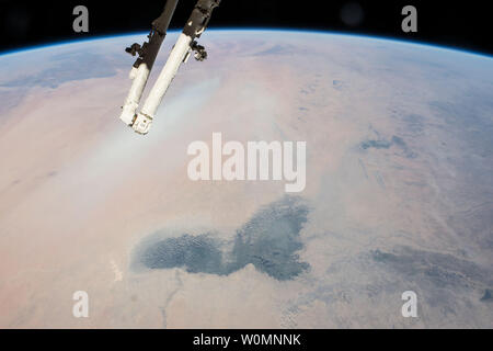 Questo est-cerca immagine, adottate il 12 Febbraio 2015 da astronauti a bordo della Stazione Spaziale Internazionale, mostra paesaggi del Sahara aride (immagine a sinistra) e la vegetazione più scuro del wetter semi-arido bosco tropicale nota come il Sahel (immagine a destra). Il verde scuro paludi del lago Ciad spiccano in primo piano di questo punto di vista. Anche se si tratta di più di 200 km di lunghezza, il lago Ciad è il piccolo residuo di un vasto lago che si è più volte occupato la maggior parte della regione in questa vista nel recente passato geologico. L'immagine cattura anche un attivo polvere plumeÑpartly oscurate dal cosiddetto Canada una Foto Stock