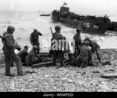 Stati Uniti L esercito amministrare l intervento di primo soccorso per i superstiti della sunken landing craft sul D-Day, 6 giugno 1944, durante l'invasione alleata di tedesco-Francia occupata. Nota M1 fucili a canna rigata portato da alcuni di questi soldati. Foto di U.S. Army Signal CorpsNational Archives/UPI Foto Stock