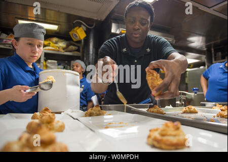 Specialista culinaria 2a classe Crystal T. Holmes (a destra) e il Marinaio Asucena C. Martinez (sinistra), prepara la pasticceria per una festa di compleanno mensili pranzo per l'equipaggio a bordo distribuita Arleigh Burke-class guidato-missile destroyer USS Barry (DDG 52) in transito attraverso il territorio della Luzon Stretto il 26 maggio 2016. Barry è di pattuglia NEGLI STATI UNITI 7 flotta area di operazioni a sostegno della sicurezza e della stabilità in Indo-Asia-Pacifico. Foto di comunicazione di massa specialista in seconda classe Kevin V. Cunningham/STATI UNITI Navy/UPI Foto Stock