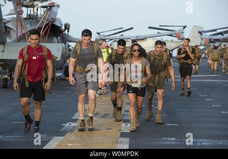 I marinai e i Marines a bordo di assalto anfibio nave USS Boxer (LHD 4) partecipano in un giorno memoriale sunrise ruck marzo sul ponte di volo il 28 maggio 2016. Boxer è l'ammiraglia per il Boxer anfibio gruppo pronto e, con l'avviato xiii Marine Expeditionary Unit, è dispiegata nel Golfo di Aden a sostegno di le operazioni di sicurezza marittima e di teatro la cooperazione in materia di sicurezza gli sforzi negli Stati Uniti Quinta Flotta area di operazioni. Foto di comunicazione di massa specialista in seconda classe Debra Daco/STATI UNITI Navy/UPI Foto Stock