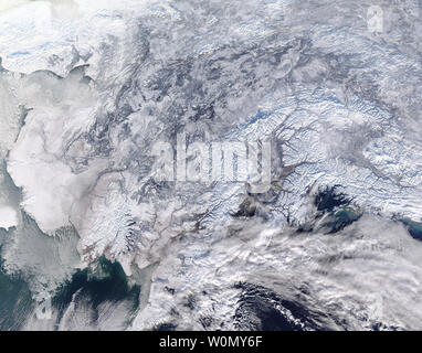 Lo stato dell'Alaska era in piena aderenza dell'inverno il 31 gennaio 2018, quando della piattaforma satellitare Terra della NASA ha superato overhead. La risoluzione moderata Imaging Spectroradiometer (dello spettroradiometro MODIS) volare a bordo ha acquisito una vera immagine a colori di una parte del sud dell'Alaska a quello stesso giorno, mostrando una scena ben coperto in inverno bianco..la neve copre il terreno dal nome che si trova vicino al confine occidentale di questa immagine, al confine con il Canada in oriente. Mare di ghiaccio si aggrappa al litorale ad ovest, galleggiante sulle acque della baia di Bristol. Pesanti archi cloud oltre il golfo di Alaska nel sud-est, portando probabilmente aggiunta Foto Stock