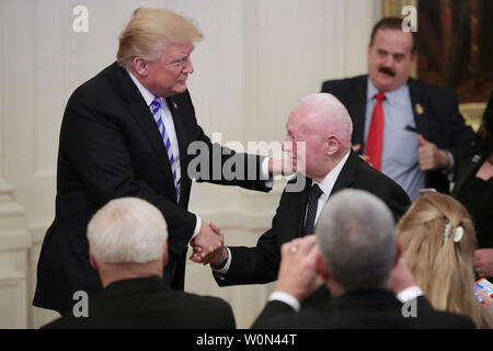 Stati Uniti Presidente Donald Trump scuote le mani con l' ex comandante del Marine Corps pensionati gen. Alfred grigio mentre commemora il trentacinquesimo anniversario dell attacco alla caserma di Beirut in Oriente stanza della casa bianca Ottobre 25, 2018 a Washington, DC. Il 23 ottobre 1983 due camion bomba ha colpito i fabbricati di stabulazione forza multinazionale in Libano (MNF) i caschi blu, uccidendo 241 negli Stati Uniti e 58 soldati francesi e 6 civili. Foto di Chip Somodevilla/UPI Foto Stock