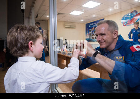 Expedition 58 Tecnico di volo David Saint-Jacques della Canadian Space Agency (CSA), destra, chi è in quarantena, rende un cuore con le mani di suo figlio, a conclusione di una conferenza stampa il 2 dicembre 2018, presso il cosmonauta Hotel di Baikonur in Kazakhstan. Lancio del razzo Soyuz è prevista per il 3 dicembre e porterà Saint-Jacques, Soyuz Commander Oleg Kononenko di Roscosmos e tecnico di volo Anne McClain della NASA in orbita per iniziare i loro sei e mezzo di mesi di missione sulla Stazione spaziale internazionale. Foto NASA da Aubrey Gemignani/UPI Foto Stock