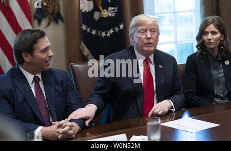 Il Presidente degli Stati Uniti, Trump si congratula con il Governatore- eleggere Ron DeSantis della Florida per la sua vittoria nel corso di un incontro con i governatori eletti alla Casa Bianca di Washington il 13 dicembre 2018. Seduto a destra è governatore- eleggere Kristi noem del Sud Dakota. Foto di Chris Kleponis Foto Stock