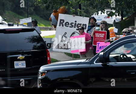Manifestanti tenere cartelli come il presidente statunitense Donald Trump's per il giro della Papamobile lascia il Trump National Golf Club Giugno 1, 2019 in sterline, Virginia. Foto di Olivier Douliery/UPI Foto Stock