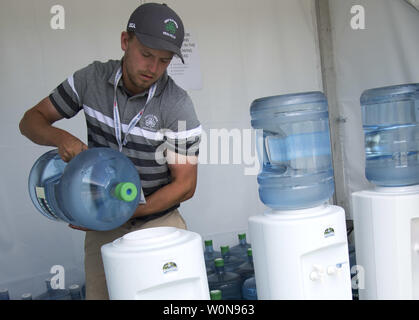 Un lavoratore si riempie un raffreddatore ad acqua e posto in corrispondenza di una stazione di idratazione durante la 117U.S. Aprire il torneo di golf al Erin Hill golf in Erin, Wisconsin il 16 giugno 2017. La Washington Ozaukee Reparto di Salute nel Wisconsin ha rilasciato una dichiarazione giovedì confermando che trovate tracce quantità di batteri E. coli in acqua potabile ad una stazione di idratazione in corso. La USGA ha spostato per fornire acqua in bottiglia in corrispondenza delle stazioni in luogo di acqua di rubinetto. Le malattie non sono stati segnalati. Foto di Kevin Dietsch/UPI Foto Stock