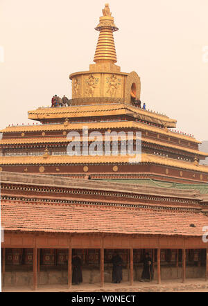Nomadi tibetani e pellegrini girare le ruote di preghiera e di pregare presso il monastero di Labrang, il più grande monastero tibetano al di fuori di Lhasa, prima per il Tibetano Monlam Festival a Xiahe, provincia di Gansu sull'altopiano tibetano, 2 febbraio 2012. Decine di migliaia di tibetani stanno celebrando il periodo del nuovo anno tibetano rendendo il loro modo di questa città e il suo monastero Labrang, la cui separazione dal Tibetano Regione Autonoma fornisce una misura di protezione dal cinese Han tenta di regolare la loro cultura. UPI/Stephen rasoio Foto Stock