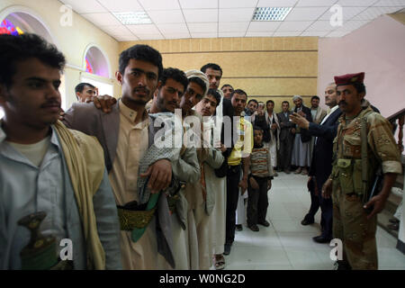 Soldati yemenita guardia come uomini di attendere per il loro voto durante le elezioni presidenziali in corrispondenza di un centro di polling in Sanaa, Yemen il 21 febbraio 2012. La elezione mette fine al presidente Ali Abdullah Saleh il 33-anno regola rigorosa in Yemen il primo stato arabo dove la rivolta si è conclusa in una soluzione negoziata. UPI/Mohammad Abdullah Foto Stock