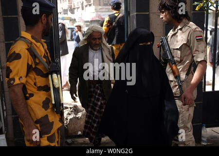 Soldati yemenita guardia come Yemenis attendere per il loro voto durante le elezioni presidenziali in corrispondenza di un centro di polling in Sanaa, Yemen il 21 febbraio 2012. La elezione mette fine al presidente Ali Abdullah Saleh il 33-anno regola rigorosa in Yemen il primo stato arabo dove la rivolta si è conclusa in una soluzione negoziata. UPI/Mohammad Abdullah Foto Stock