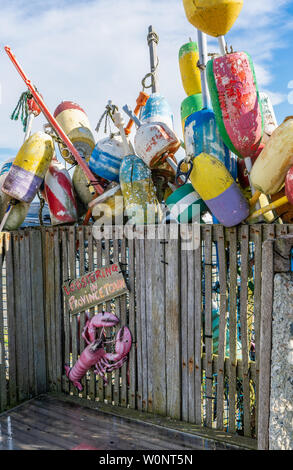 Lobstering nel segno a Provincetown su un legno stagionato banco con molti più colori boa galleggianti dietro Foto Stock