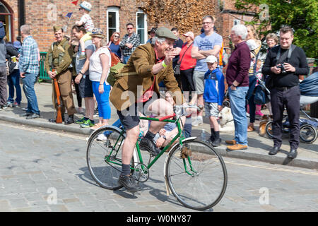 Un cavaliere solitario su un ciclo di antiquariato in Lymm trasporto storico sfilano per le vie del paese Foto Stock