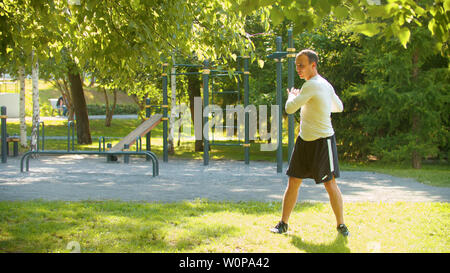 L'uomo culturista eseguire il warm-up prima di esercizi di base - Metà shot Foto Stock