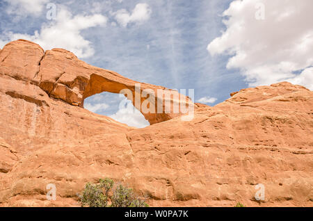 Vista ravvicinata della Skyline Arch con belle, soffici nuvole nel Parco Nazionale di Arches nei pressi di Moab, Utah Foto Stock