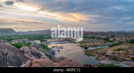 A gorgeous view over a rocky landscape with a river at sunset Foto Stock
