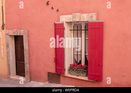 Roussillon, Francia - 22 Gennaio 2019: le case e gli edifici con facciata di colore ocra con pulito cielo blu come sfondo Foto Stock