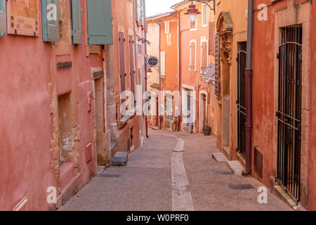 Roussillon, Francia - 22 Gennaio 2019: le case e gli edifici con facciata di colore ocra con pulito cielo blu come sfondo Foto Stock