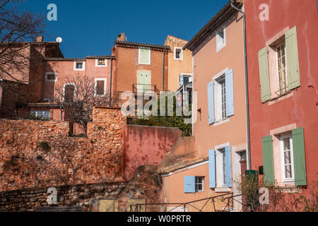 Roussillon, Francia - 22 Gennaio 2019: le case e gli edifici con facciata di colore ocra con pulito cielo blu come sfondo Foto Stock