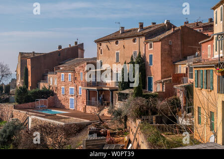 Roussillon, Francia - 22 Gennaio 2019: le case e gli edifici con facciata di colore ocra con pulito cielo blu come sfondo Foto Stock