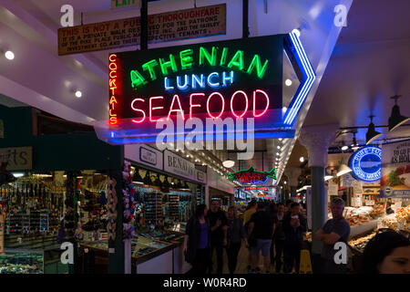 Stati Uniti d'America, USA, Seattle, Washington, Pike Place, 10 maggio 2019. Pubblicità illuminato al di sopra di un mercato pubblico stand con frutti di mare Foto Stock