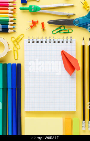 Scuola di variopinti articoli di cancelleria e forniture raccolta su sfondo giallo. Organizzate lo spazio desktop. Copia dello spazio. Foto Stock