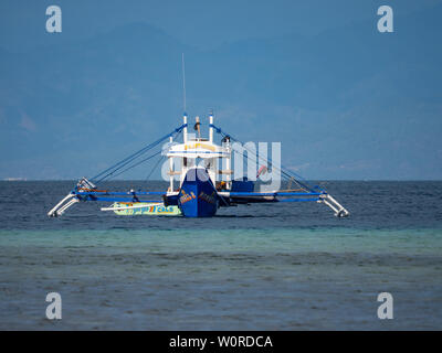 Maasim, Filippine - 23 Maggio 2019: ancorata, blu outrigger barca da pesca in Tinito, un villaggio in Maasim, Sarangani Provincia delle Filippine Foto Stock