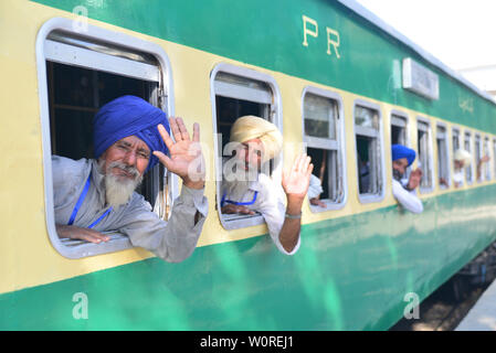 Lahore, Pakistan. Il 27 giugno, 2019. La religione Sikh indiani pellegrini arrivati a Lahore Stazione ferroviaria via treno da India attraverso Wagah Border come essi venuti ad assistere centottantesimo morte anniversario del Maharaja Ranjeet Singh a Lahore il 27 giugno 2019. 413 Sikh indiani pellegrini sono attesi in Pakistan per celebrare il centottantesimo morte anniversario del Maharaja Ranjit Singh, leader dell'impero Sikh. Maharaja Ranjeet Singh, che era un ex righello Sikh del regno Punjab regione sotto dominazione coloniale britannica. Credito: Rana Sajid Hussain/Pacific Press/Alamy Live News Foto Stock