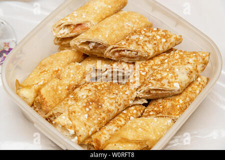 Frittelle farcite in un contenitore per alimenti. Deliziosi pancake prima colazione Foto Stock