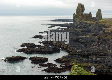 Londrangar scogliere di basalto in Islanda, Snaefellsnes Peninsula sulla costa atlantica. Nero paesaggio vulcanico con pinnacoli di roccia Foto Stock