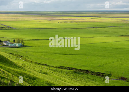 Islandese di case coloniche nel mezzo di un paesaggio verdeggiante pianura. Skogar, Islanda Foto Stock