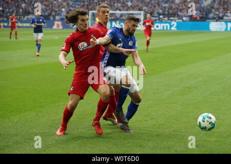 V. li. im Zweikampf Caglar Söyüncü (Freiburg) vs Daniel Caligiuri (Schalke 04) im Spiel der 1. BL: 17-18 -28. Spieltag - Schalke 04 vs SC Freiburg Foto Stock