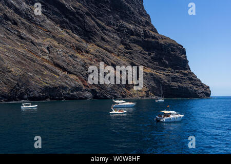 TENERIFE, Isole canarie, Spagna - 26 luglio 2018: yacht e barche di turisti vicino le scogliere verticali Acantilados de Los Gigantes (Rupi dei Giganti). Vista dall'Oceano Atlantico. Foto Stock