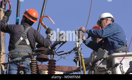 Gli elettricisti del popolo israeliano Electric Co il fissaggio ad alta tensione delle linee elettriche, la sostituzione di un trasformatore dopo il grande incendio di Haifa, Israele, Dicembre 25, 2018 Foto Stock