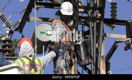 Gli elettricisti del popolo israeliano Electric Co il fissaggio ad alta tensione delle linee elettriche, la sostituzione di un trasformatore dopo il grande incendio di Haifa, Israele, Dicembre 25, 2018 Foto Stock