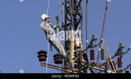 Gli elettricisti del popolo israeliano Electric Co il fissaggio ad alta tensione delle linee elettriche, la sostituzione di un trasformatore dopo il grande incendio di Haifa, Israele, Dicembre 25, 2018 Foto Stock