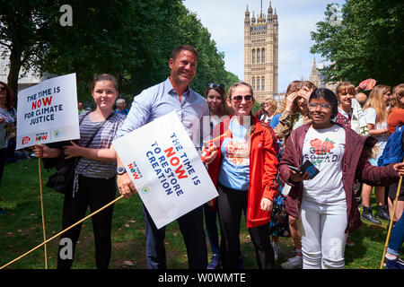 Steve Backshall, naturalista e Bafta t.v. vincente presenter, scrittore, meglio conosciuta per il 'Deadly 60' serie televisiva BBC si unisce a un gruppo di giovani per il cristiano aiuti allo sciopero globale per il clima nella torre di Victoria Gardens vicino alla Casa del Parlamento. Christian Aid è il funzionario di sollievo e di agenzia di sviluppo di 41 britannici e chiese irlandese al lavoro per arrestare la povertà e fornisce aiuto in caso di catastrofe nei paesi in via di sviluppo. La manifestazione è stata organizzata da CAFOD, Agenzia Cattolica per lo sviluppo estero. Cartelli recanti lo slogan "Il tempo è ora' e 'Taglia l'avidità, non verde' sono stati portati dal gruppo. Foto Stock